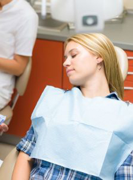 Photo of female patient sitting and relaxing in a dental chair, for information on sedation dentistry from Plano female dentist, Dr. Miranda Lacy.