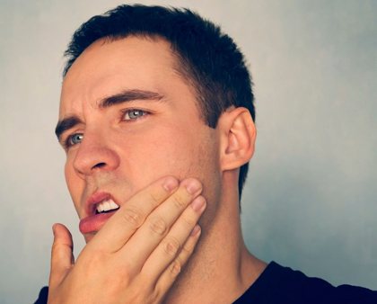 Man holding his face with tooth pain - for sedation dentistry info from Miranda Lacy, DDS of Plano, TX